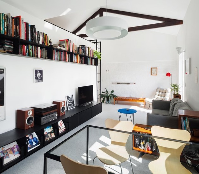 open concept living and dining area with floating book shelf