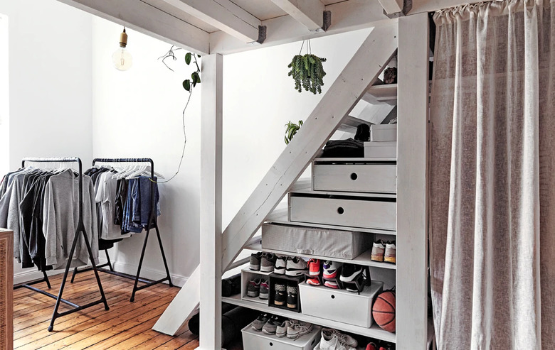 bedroom storage idea under stairs hidden by IKEA curtains