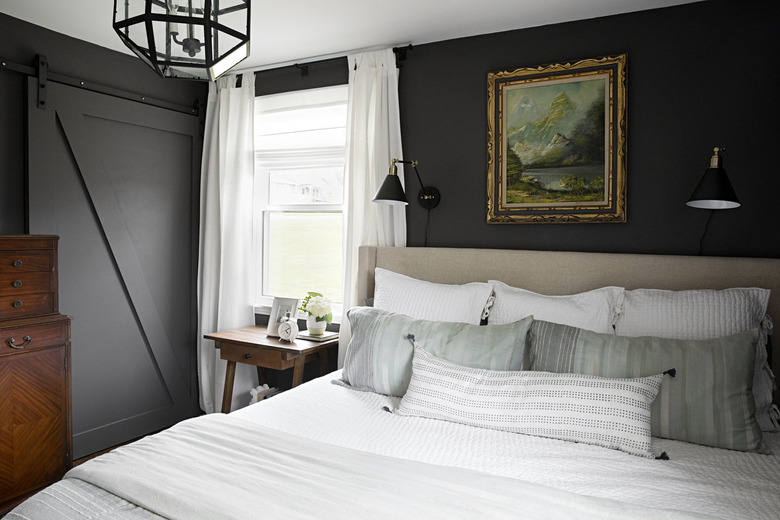 Vintage-inspired dark gray bedroom idea with upholstered headboard and sliding barn door