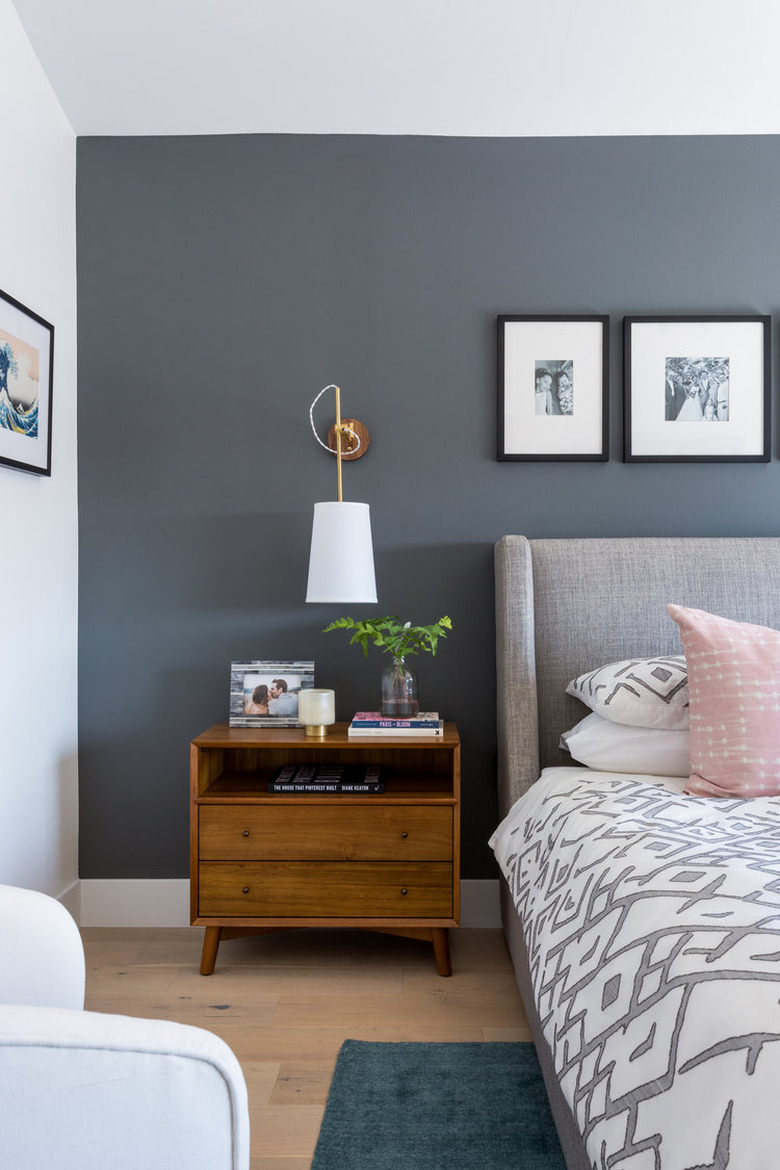 Eclectic gray bedroom idea with upholstered headboard and wood nightstand