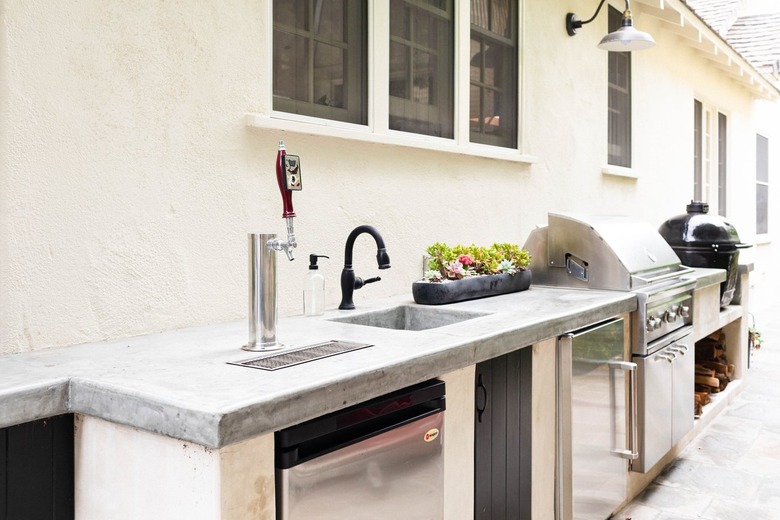 outdoor kitchen with stainless steel appliances and stone countertop