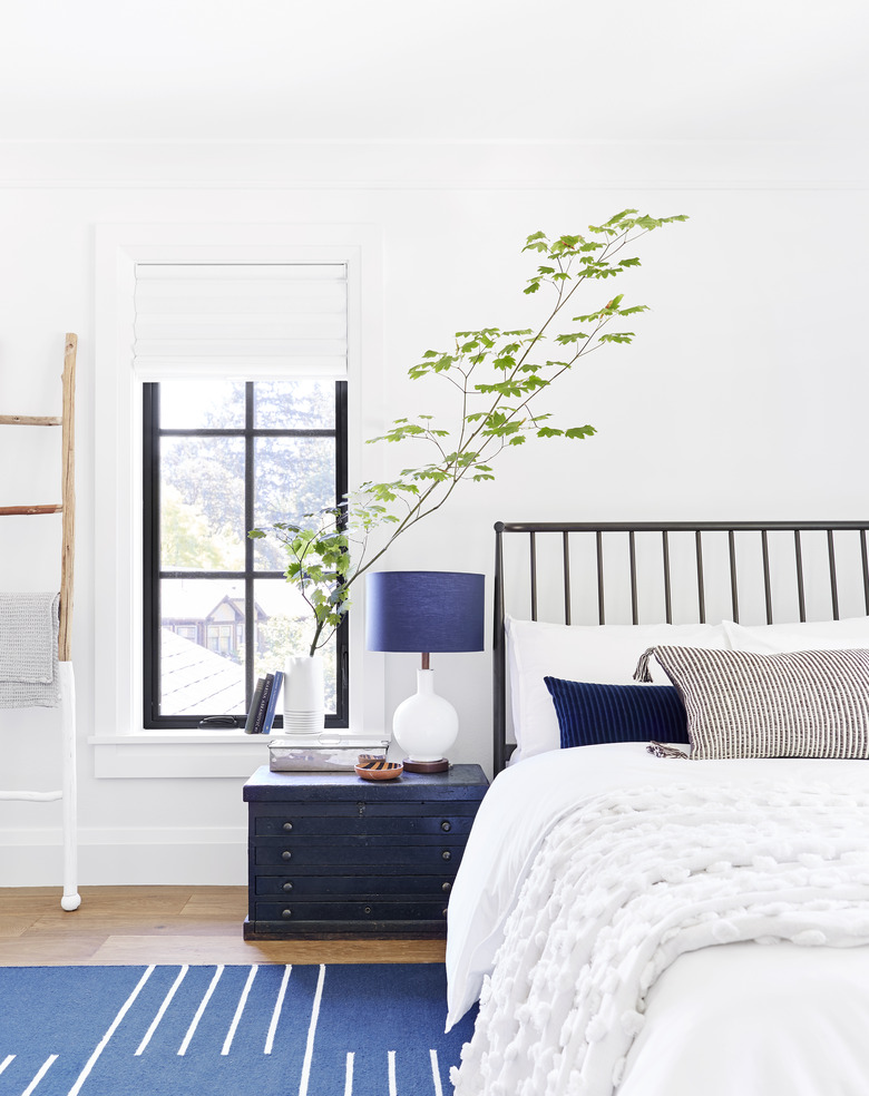 Rustic bedroom idea with blue decor accents and black headboard