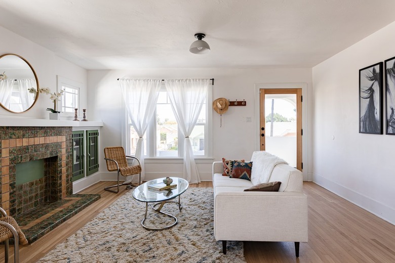 living room with round mirror over fireplace