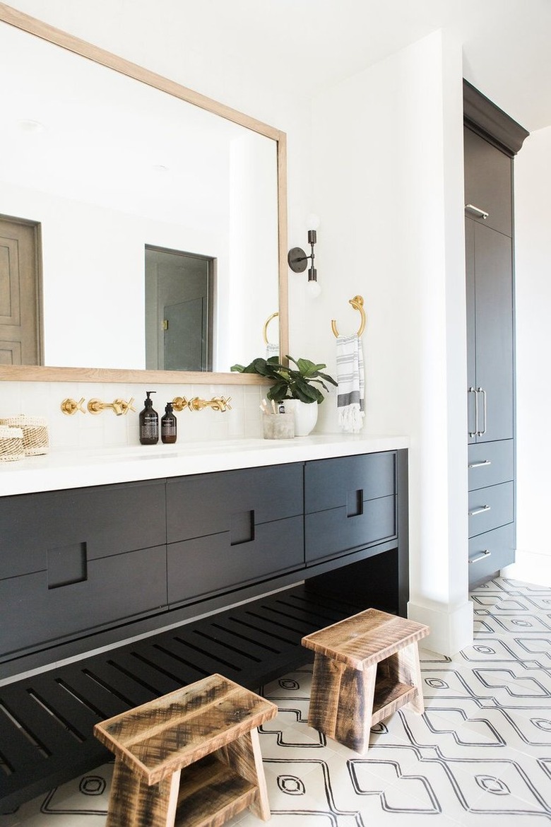 black vanity cabinet with black and white tile flooring