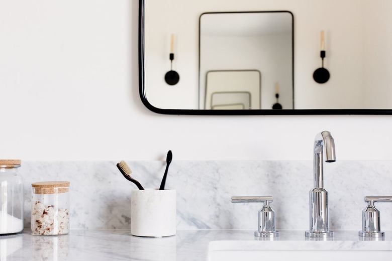 bathroom with bronze mirror and polished chrome faucet at sink