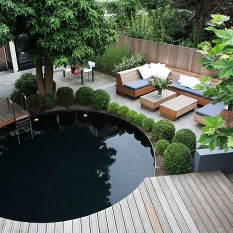 patio with round swimming pool and wooden deck