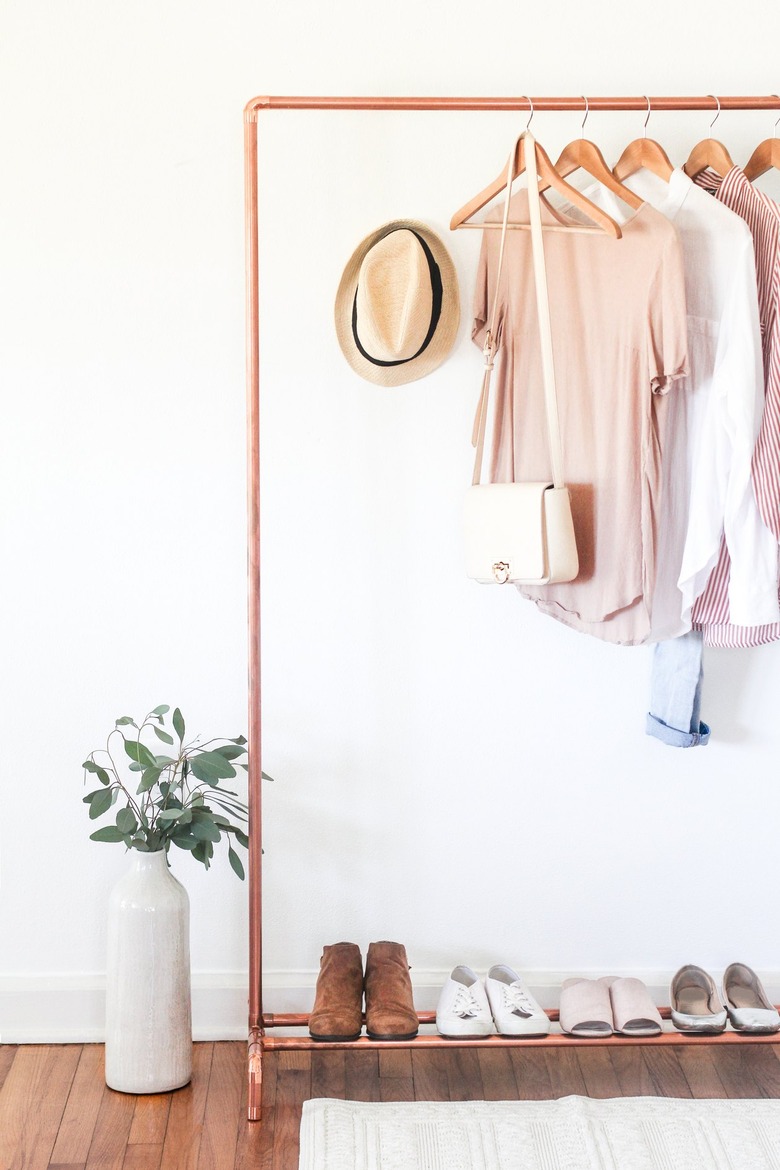 a clothing rack with a shoe rack attached made from copper pipe