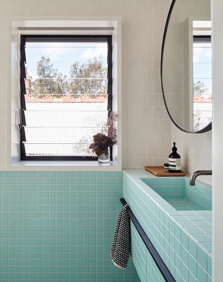 Aqua tile bathroom sink idea with white tile and round mirror