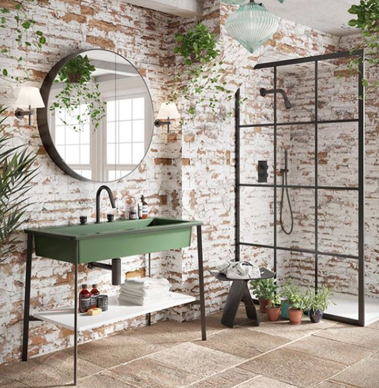 green bathroom sink idea with brick walls and round mirror