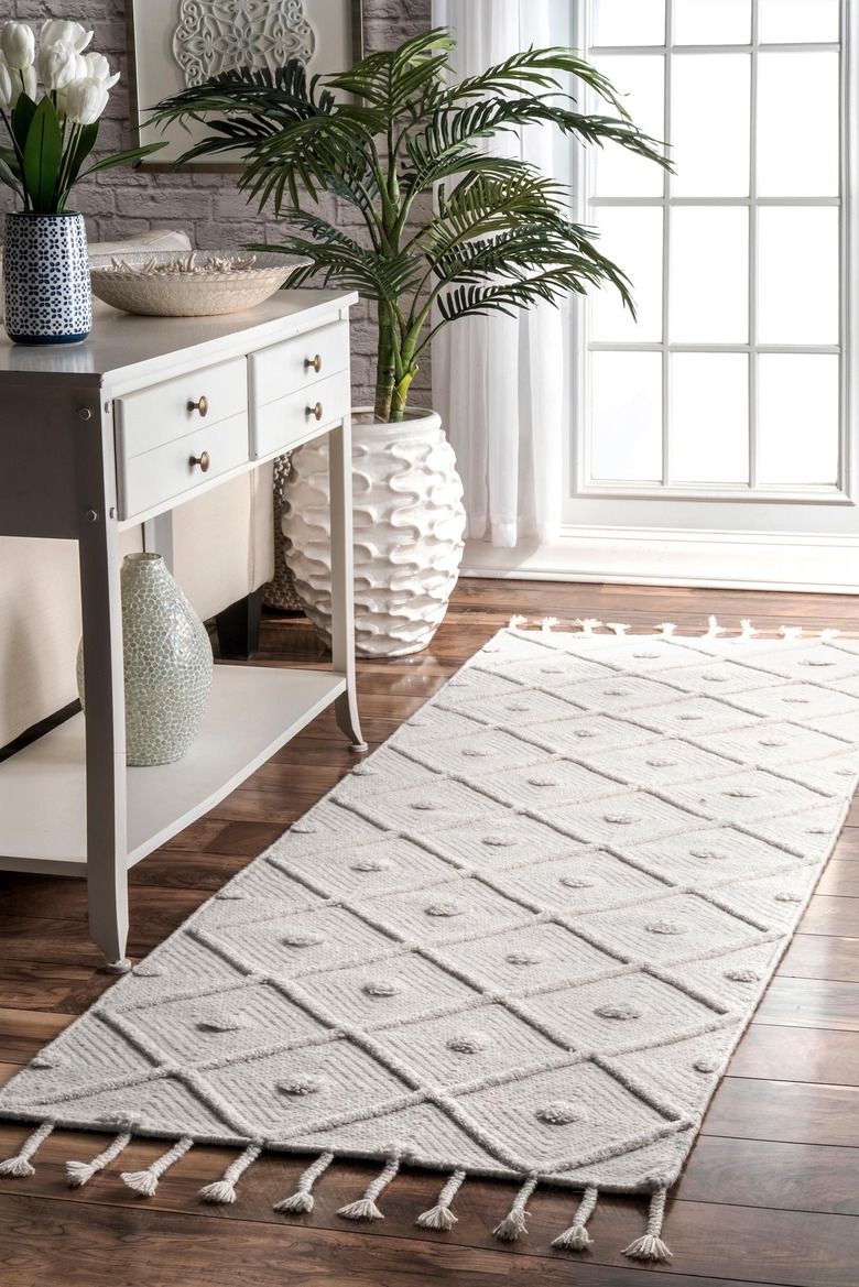 trellis rug near dresser and plant