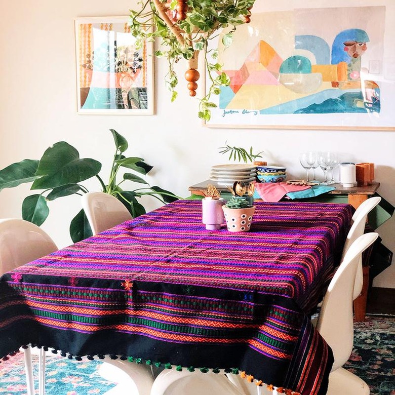 dining room space with hanging plant and framed artworks