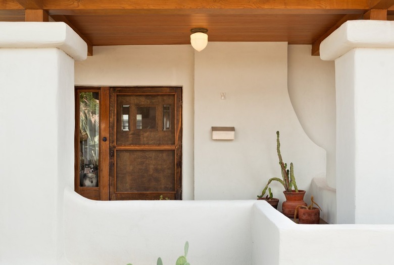 A front porch of a white House with wood accents