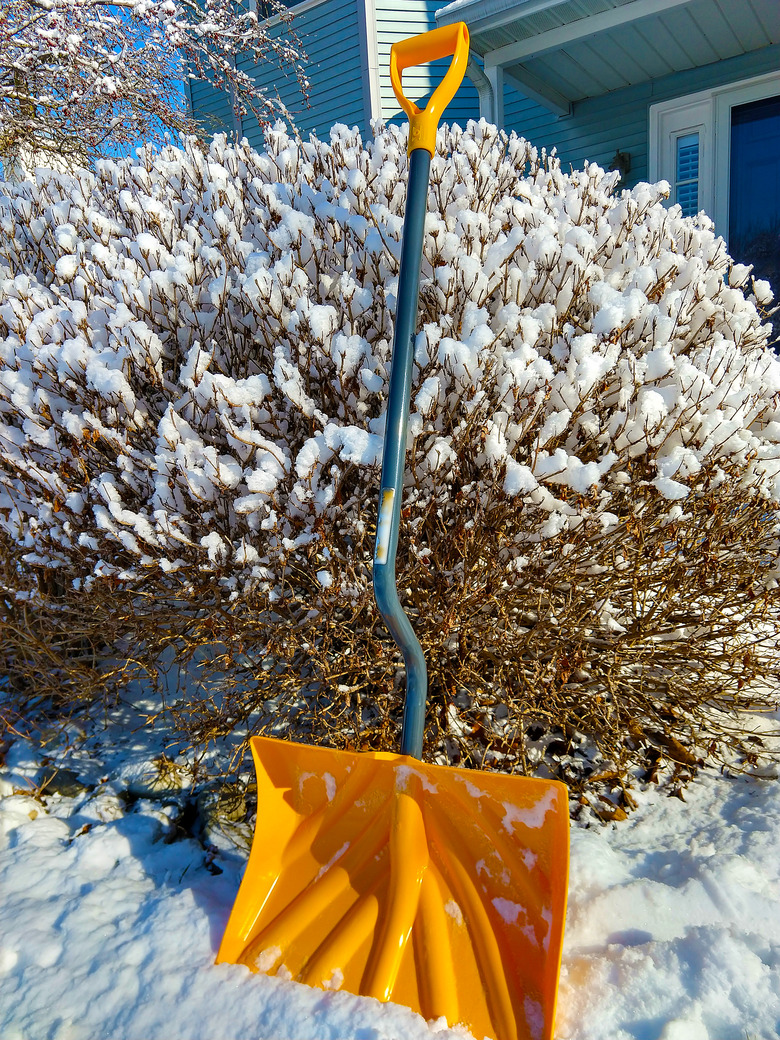 Snow shovel in snow.