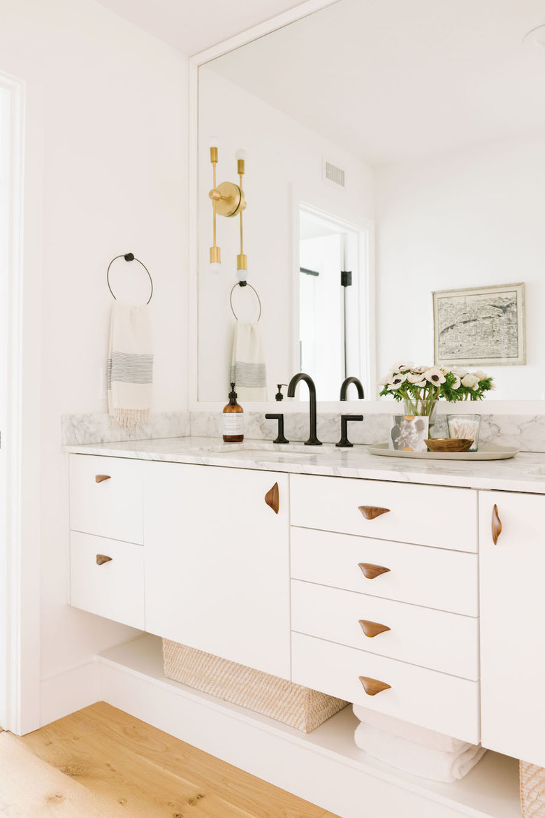 undermount bathroom sink with white cabinets and marble countertop