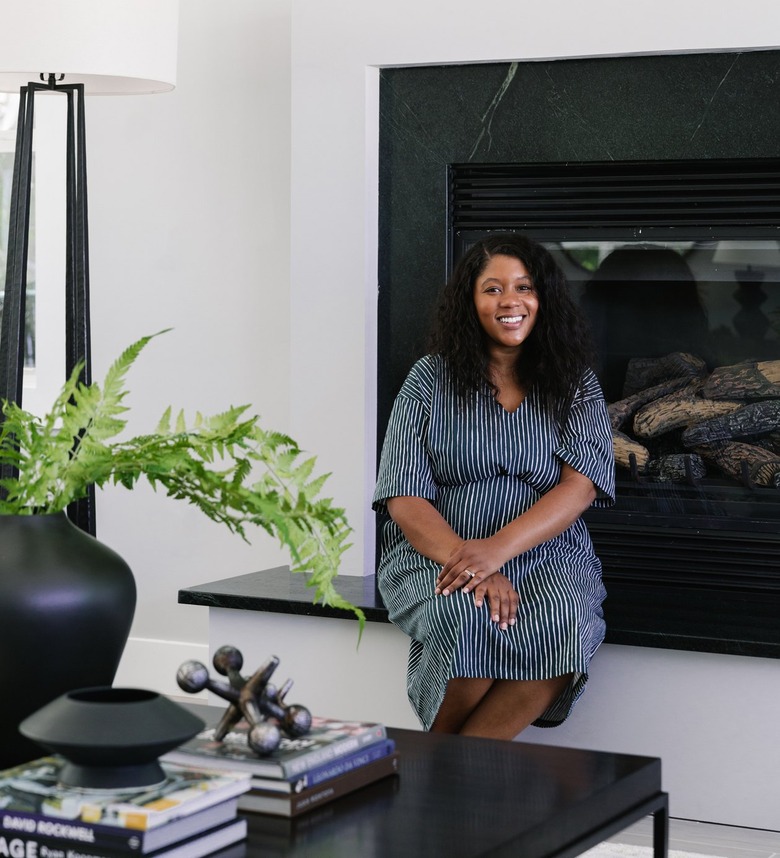 person sitting near fireplace with coffee table nearby