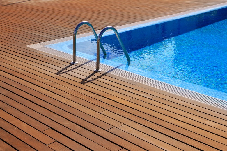 blue swimming pool with teak wood flooring