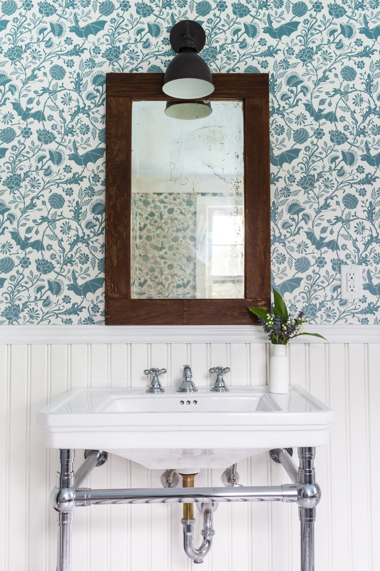 apartment bathroom idea with wainscoting and wallpaper and console sink