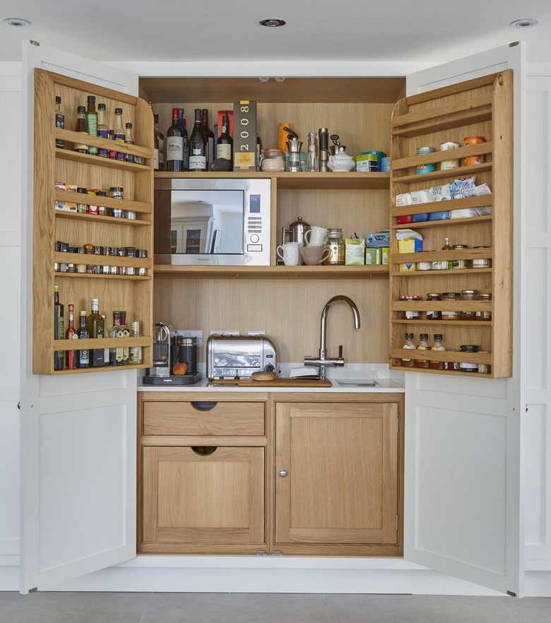 appliance garage meets pantry with sink, microwave and spice rack doors