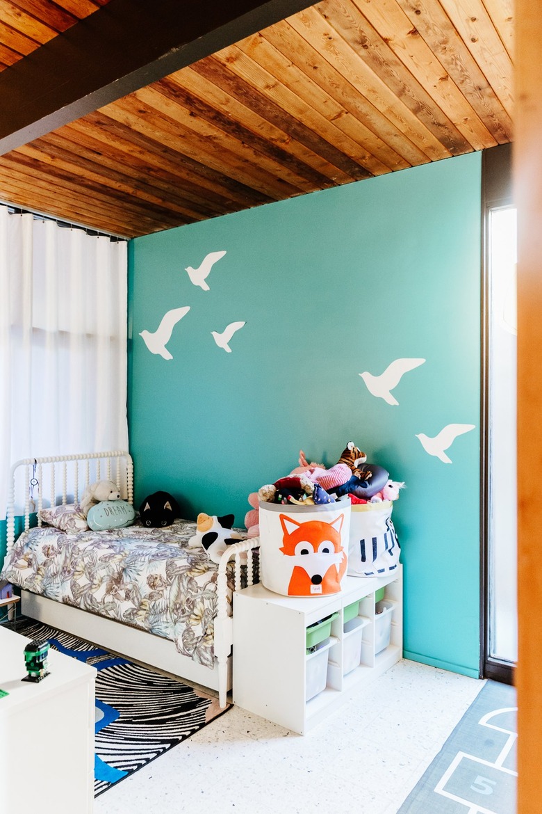 Child's room with aqua bird mural on wall