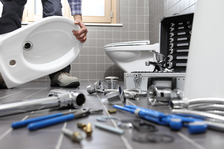 plumber at work in a bathroom, plumbing repair service, assemble and install concept