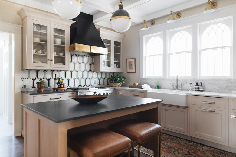 art deco backsplash with beige cabinets and farmhouse sink