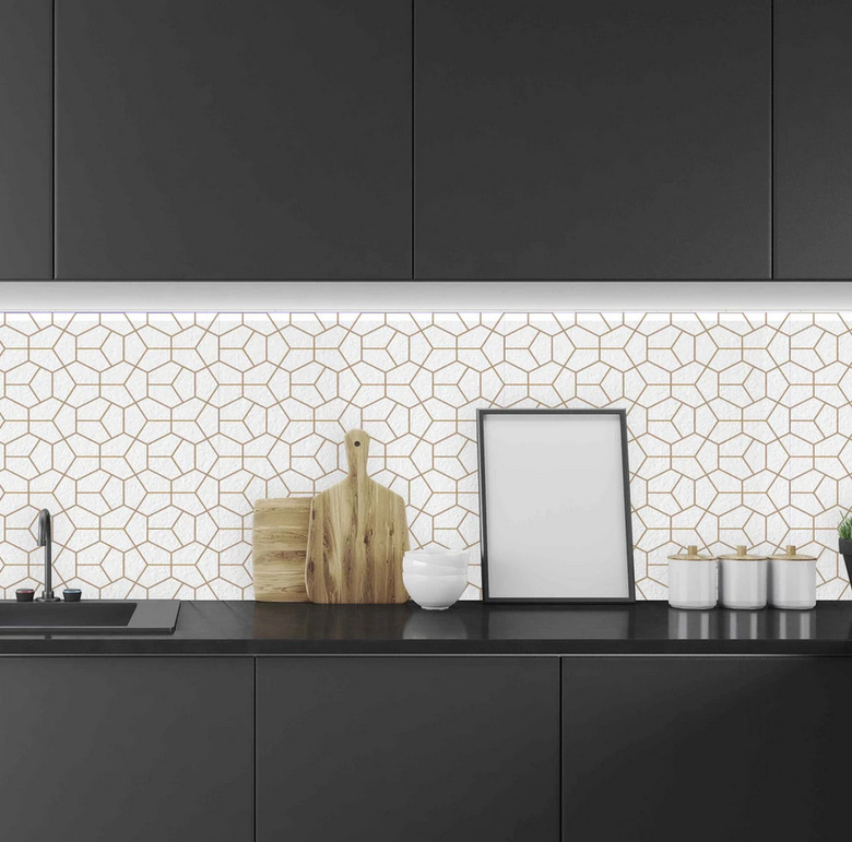 Geometric white and gold art deco backsplash with black kitchen cabinets