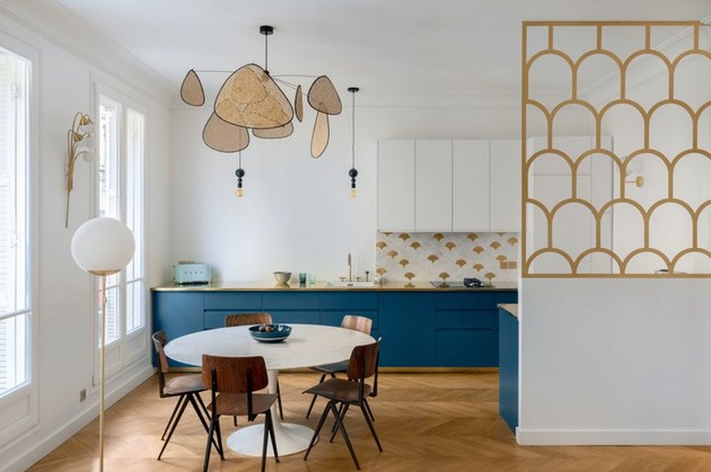 art deco kitchen with oval tulip dining table and blue cabinets