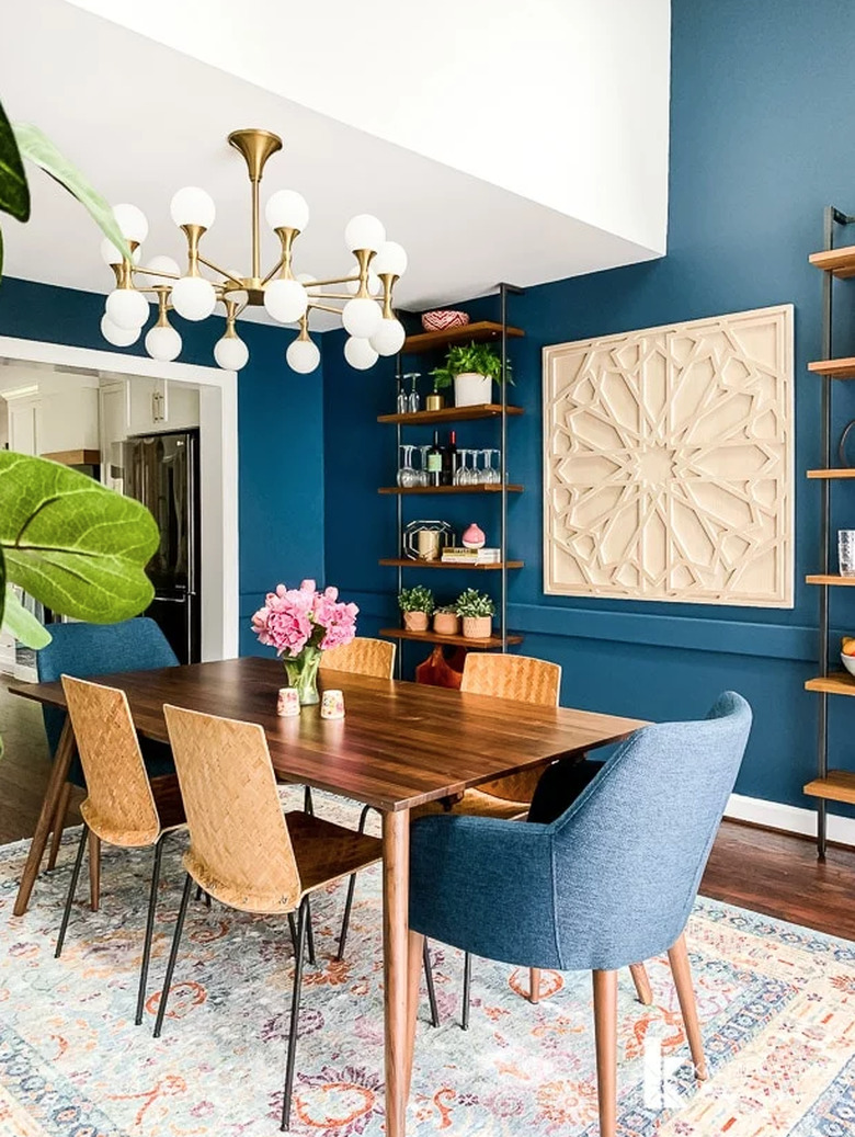 Blue art deco dining room with geometric wall art and modern chandelier