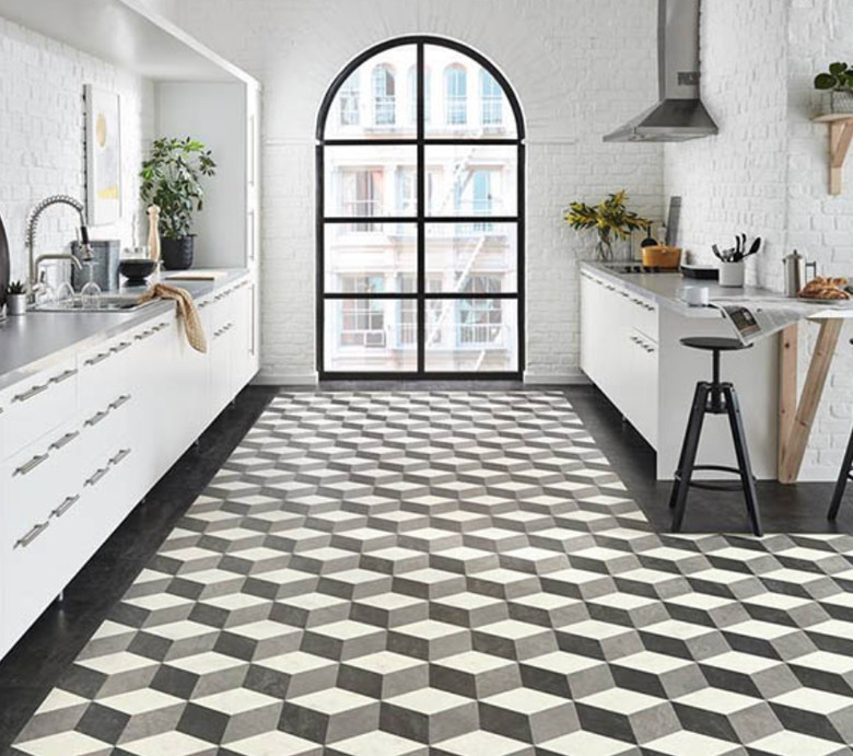 Three dimensional stepped pattern tile floor in a white modern kitchen with large picture window.