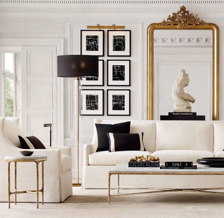 white art deco living room with large, ornate floor mirror and white sofa