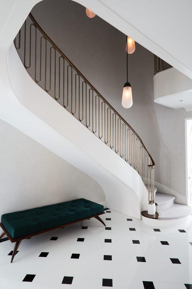 art deco staircase with modern light fixture and brass railing