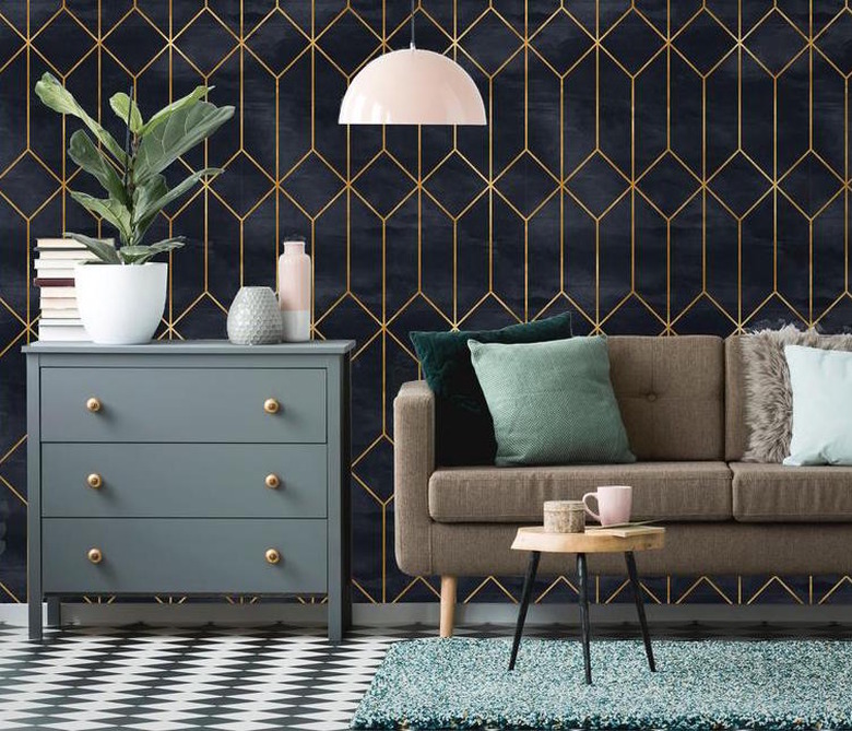 living room space with art deco wallpaper and brown couch