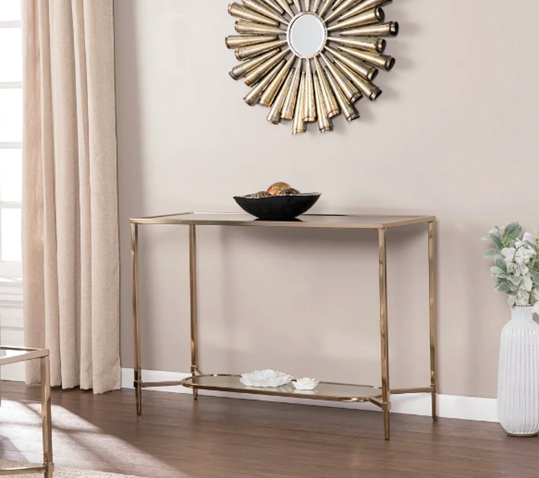 beige wall with art deco mirror and gold table