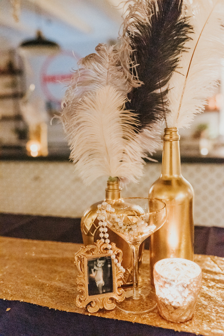 art deco themed party idea with feather centerpieces and gold decor