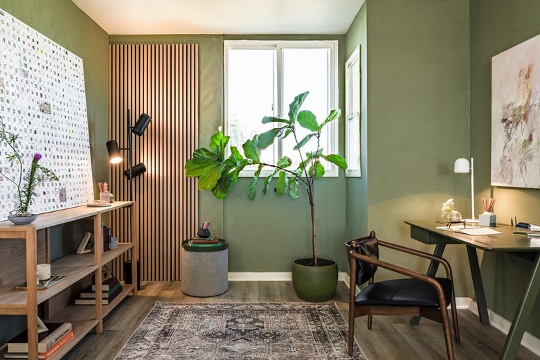 room with green walls and desk and plant