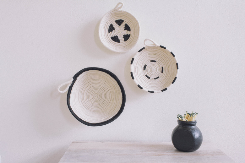 Three DIY cotton rope bowls hung on wall black and white graphic patterns