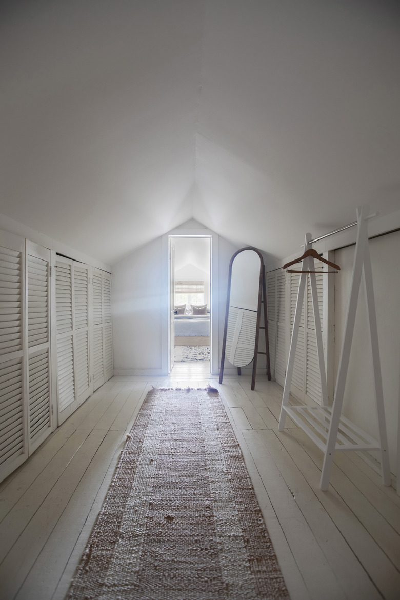 Attic Closet Ideas with standalone clothing rack and vintage runner