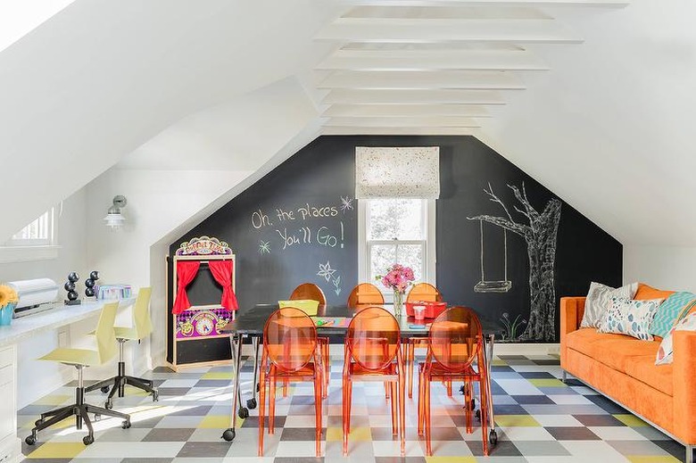 attic playroom with chalkboard wall, orange chairs, and orange sofa