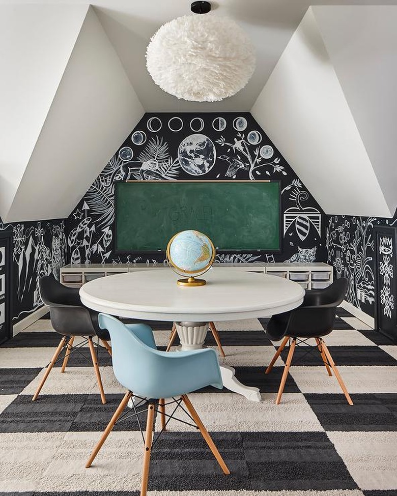 attic playroom with black and white carpet tiles and green chalkboard