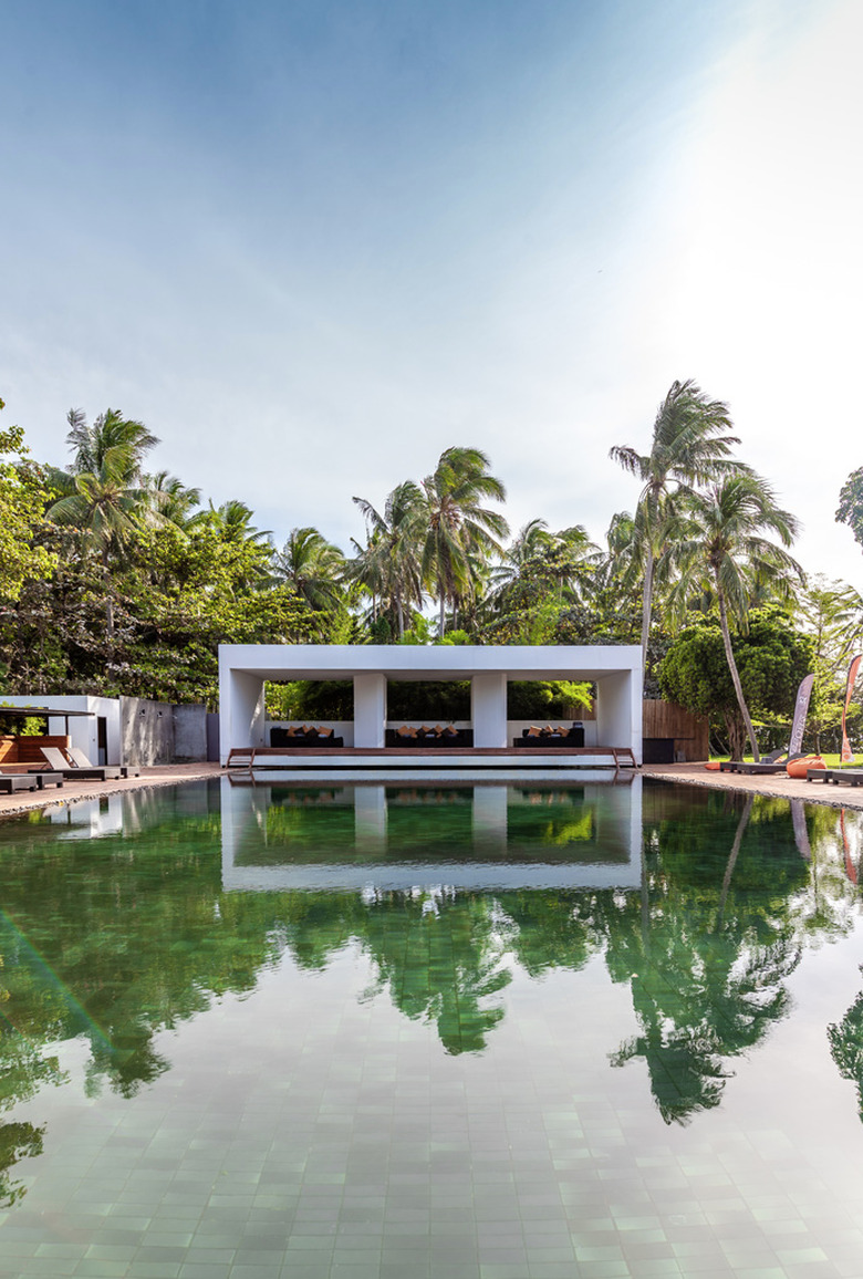 Green tile backyard pool design with palm trees in Thailand