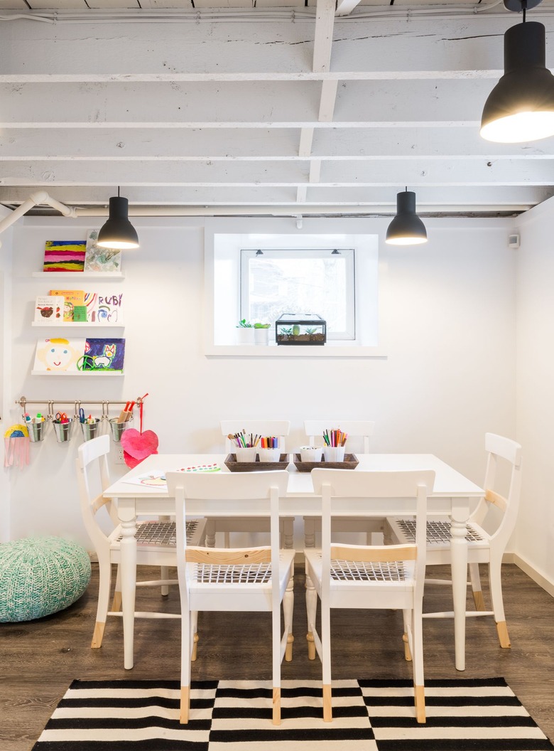 white basement ceiling ideas in kids space with striped rug and white table