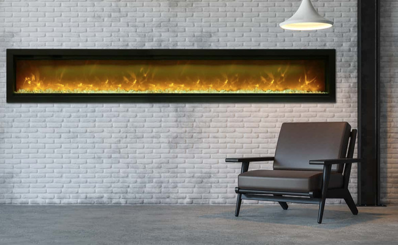 long basement fireplace set in white brick wall with hanging pendant