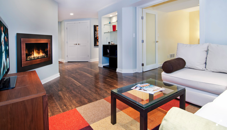 basement fireplace in basement with white walls and white couches