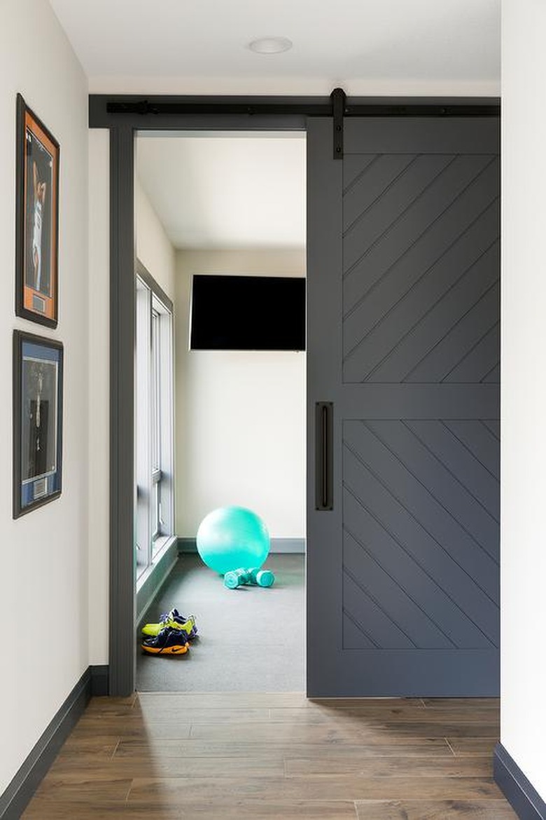 basement gym with sliding barn style door