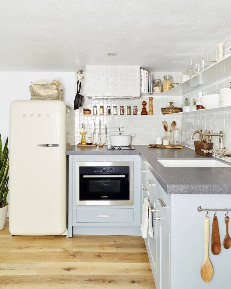 basement kitchen with blue cabinets and cream Smeg fridge