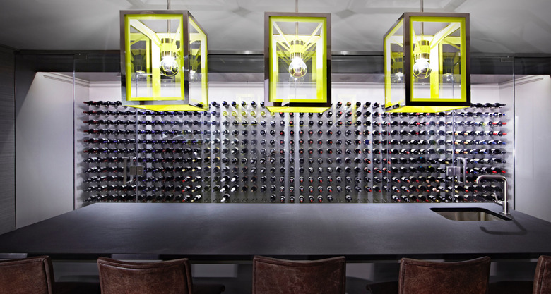 basement lighting in basement with dark gray bar and wine cellar, lime green pendant lights.