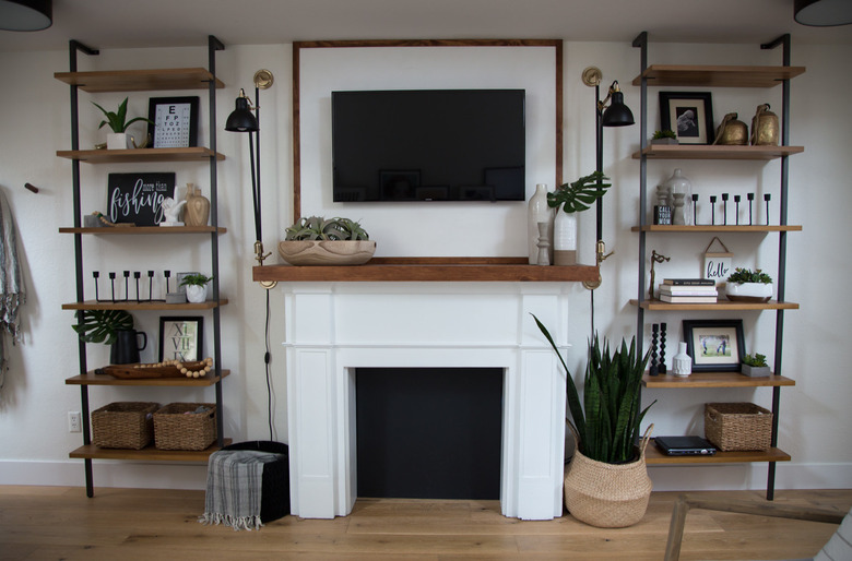 basement storage ideas with rustic metal shelving, fireplace, flat screen, and wood floors