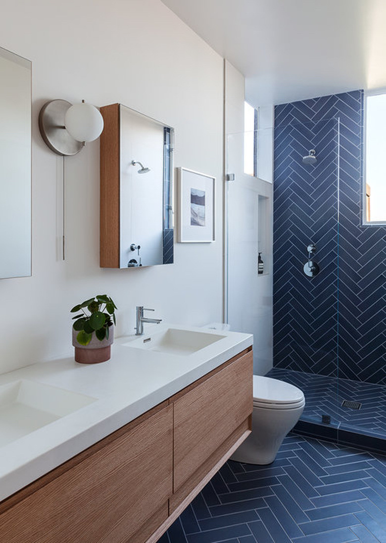 navy blue ceramic tile in herringbone pattern on bathroom wall and floor