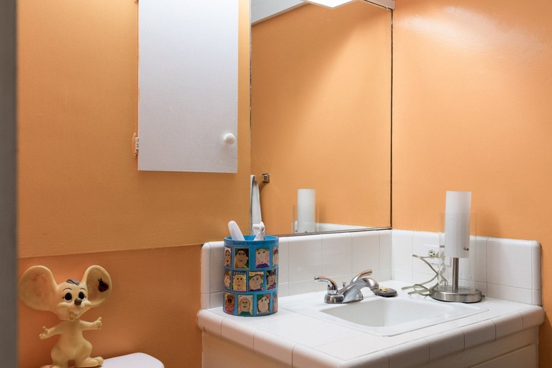 orange walls and mirror in small bathroom