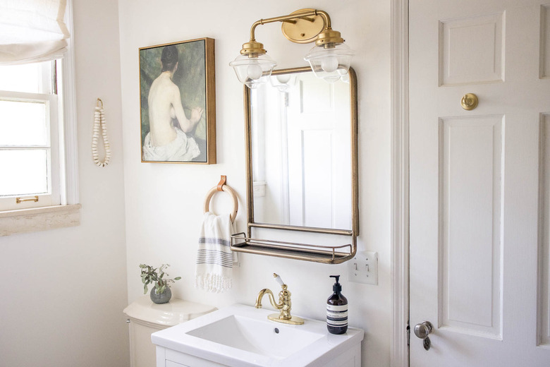 vintage inspired bathroom with oil painting and brass fixutres